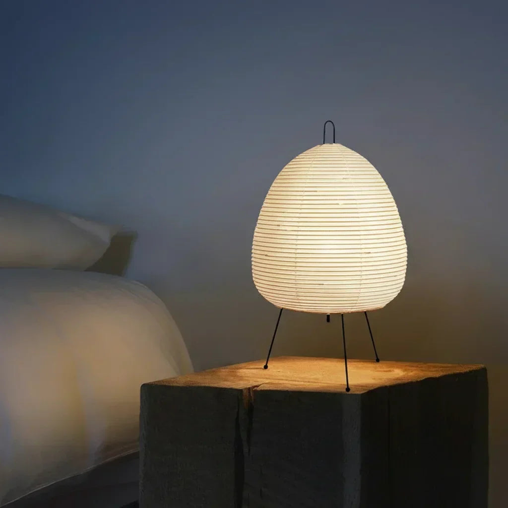 Lampe en papier de riz allumée sur une table de chevet