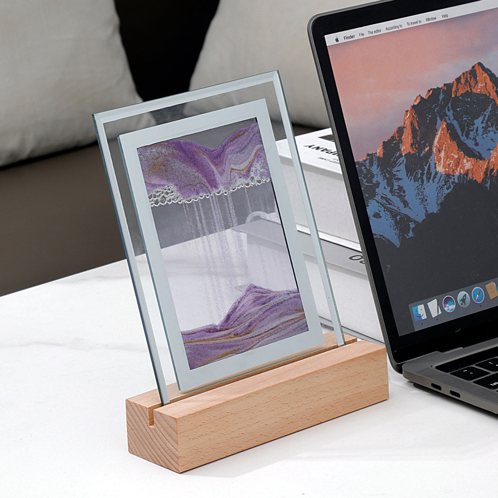 Lampe sable mouvant violette à cadre rectangulaire sur socle en bois, posée sur un bureau