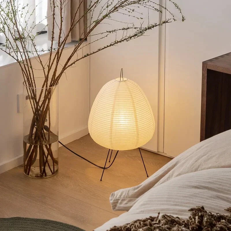 Lampe papier de riz au sol près d'un lit