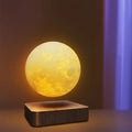 Lampe lune flottante allumée au-dessus de son socle en bois