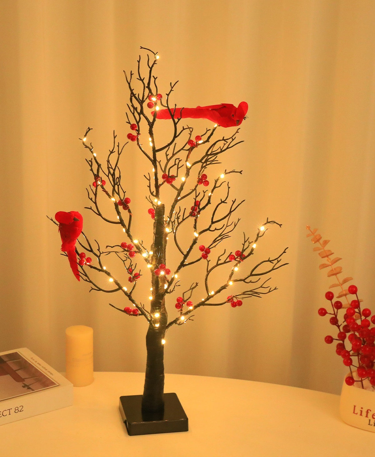 Arbre lumineux aux branches noires et oiseaux cardinaux rouges, lumière chaude
