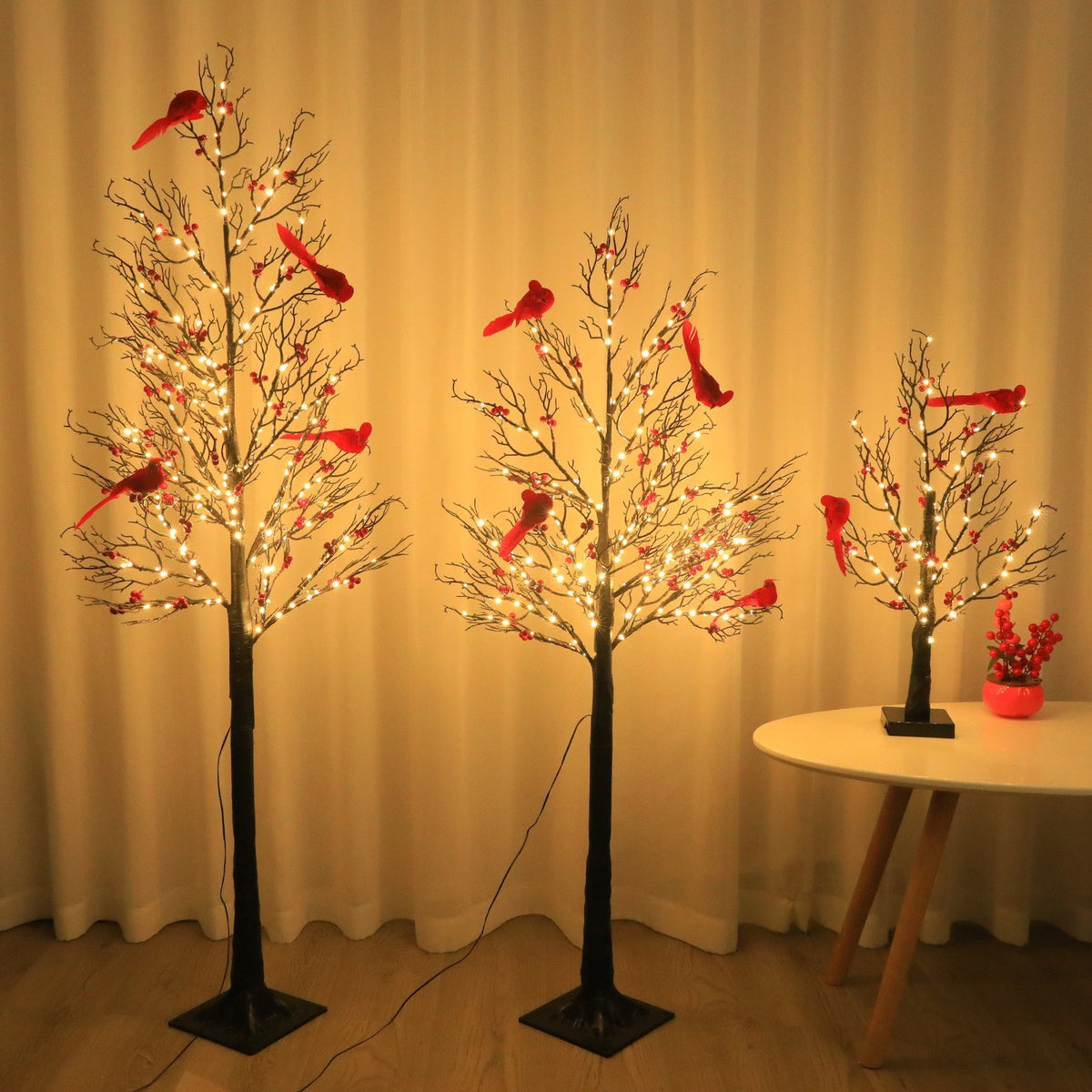 Arbre lumineux aux baies rouges et cardinaux dans un salon