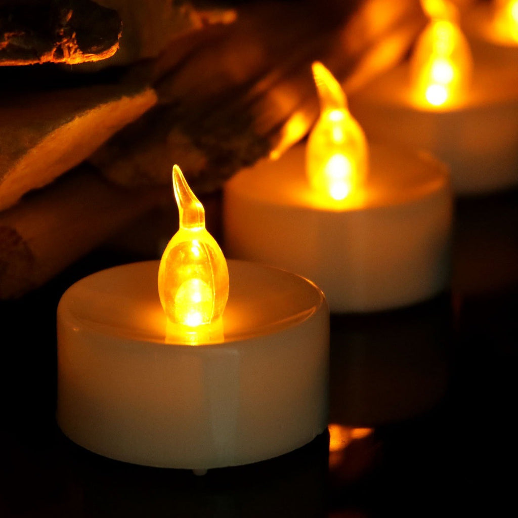 Gros plan sur la flamme LED ambrée d’une bougie chauffe-plat