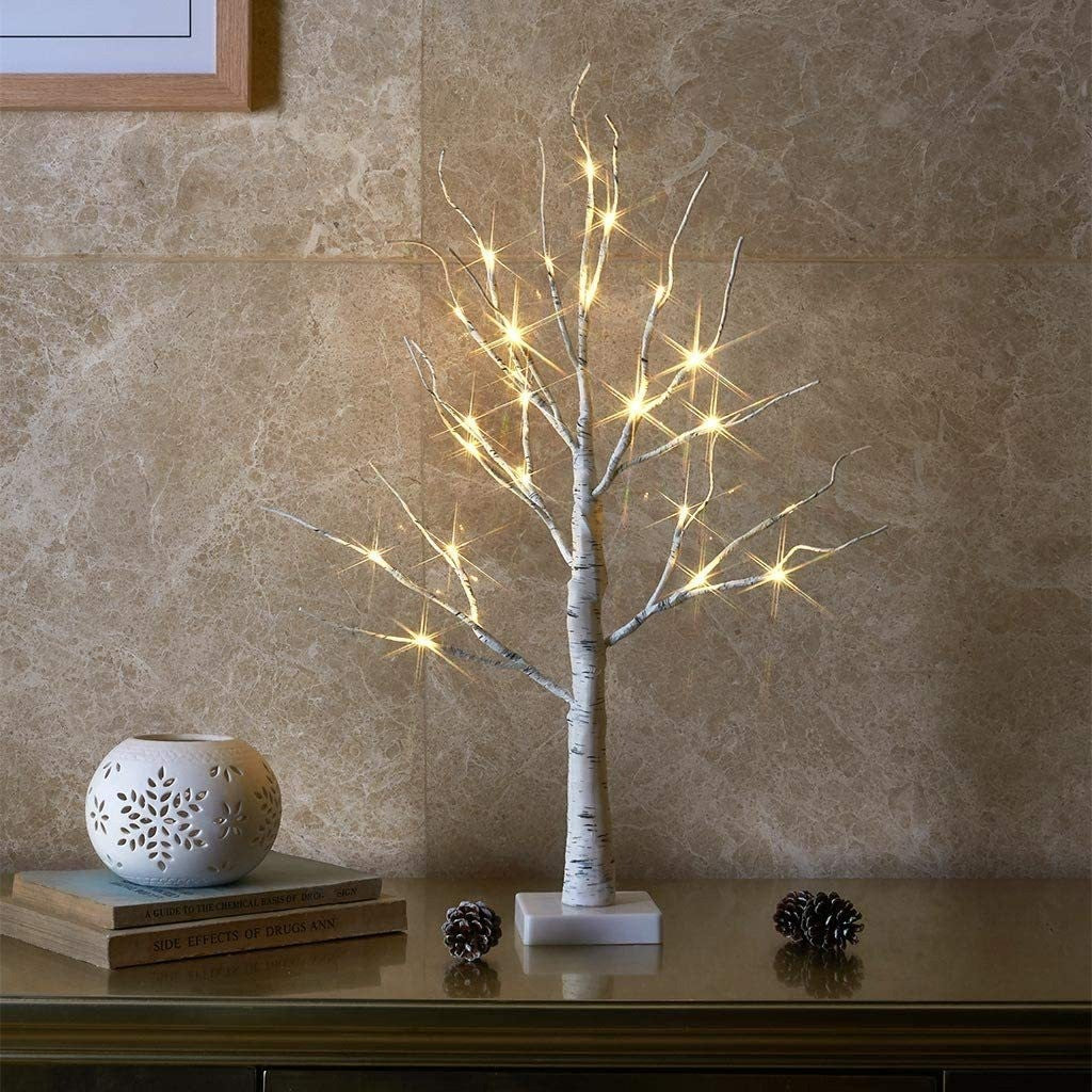 Bouleau lumineux blanc aux branches ornées de LED, posé sur une cheminée