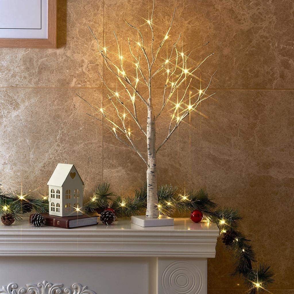 Petit bouleau lumineux blanc allumé au milieu d’une déco de Noël