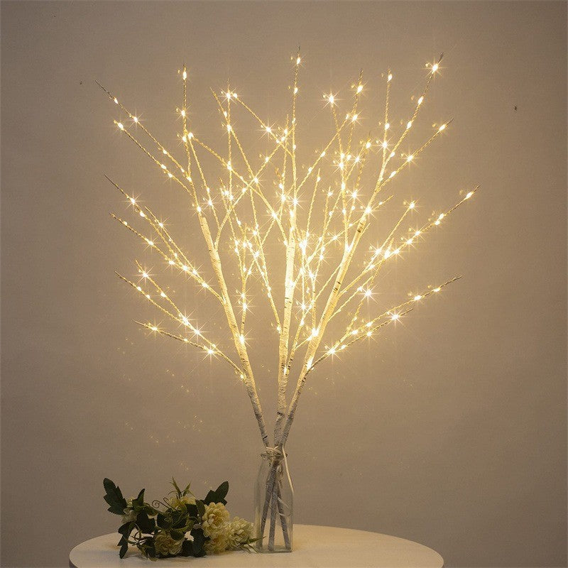 Branches de bouleau lumineuses posées sur une table