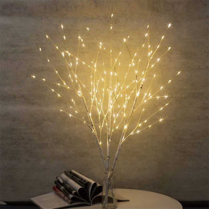 Branches lumineuses effet bouleau près d’un livre ouvert