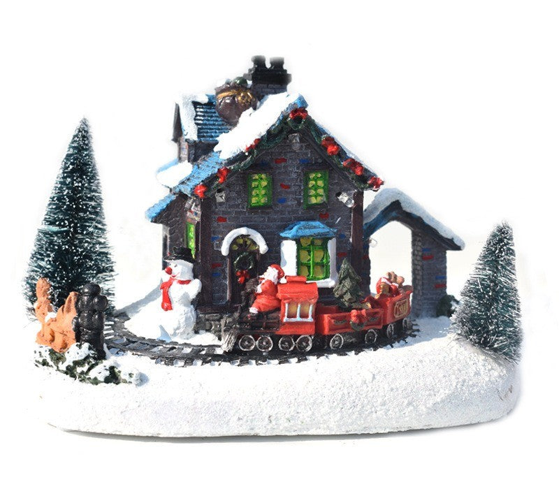 Chalet enneigé en résine avec sapins, traîneau et bonhomme de neige