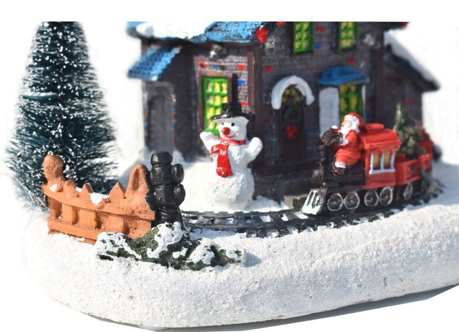 Détail du chalet : bonhomme de neige et sapin au pied de la maison