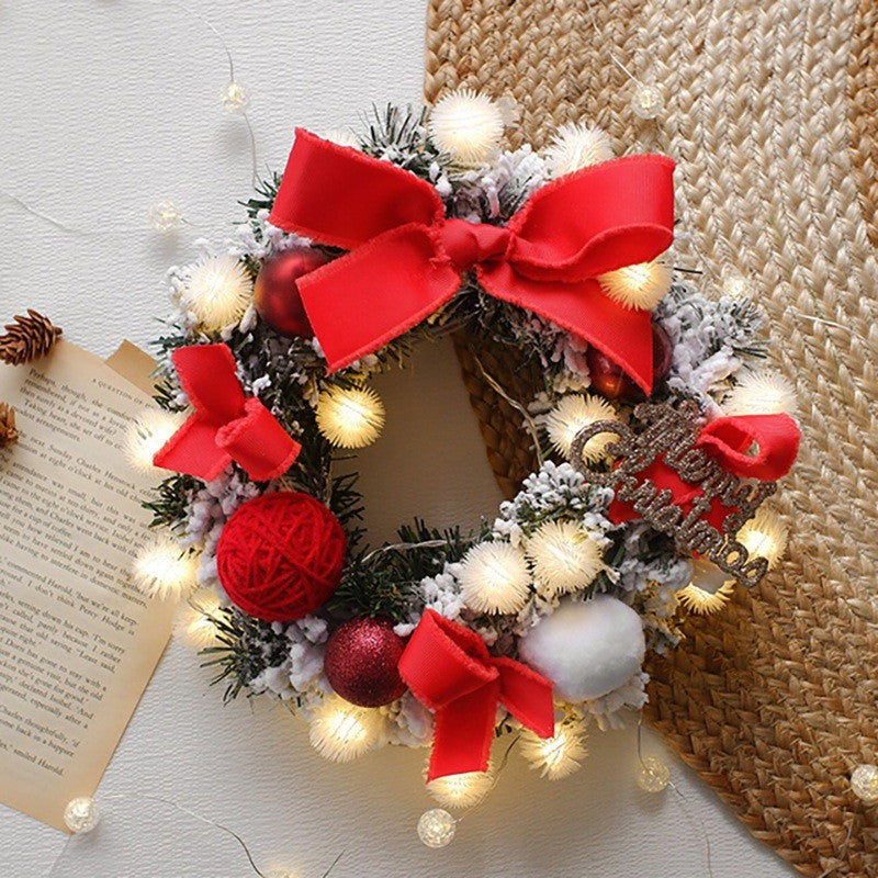 Couronne de Noël lumineuse à gros nœud rouge, boules et pommes de pin
