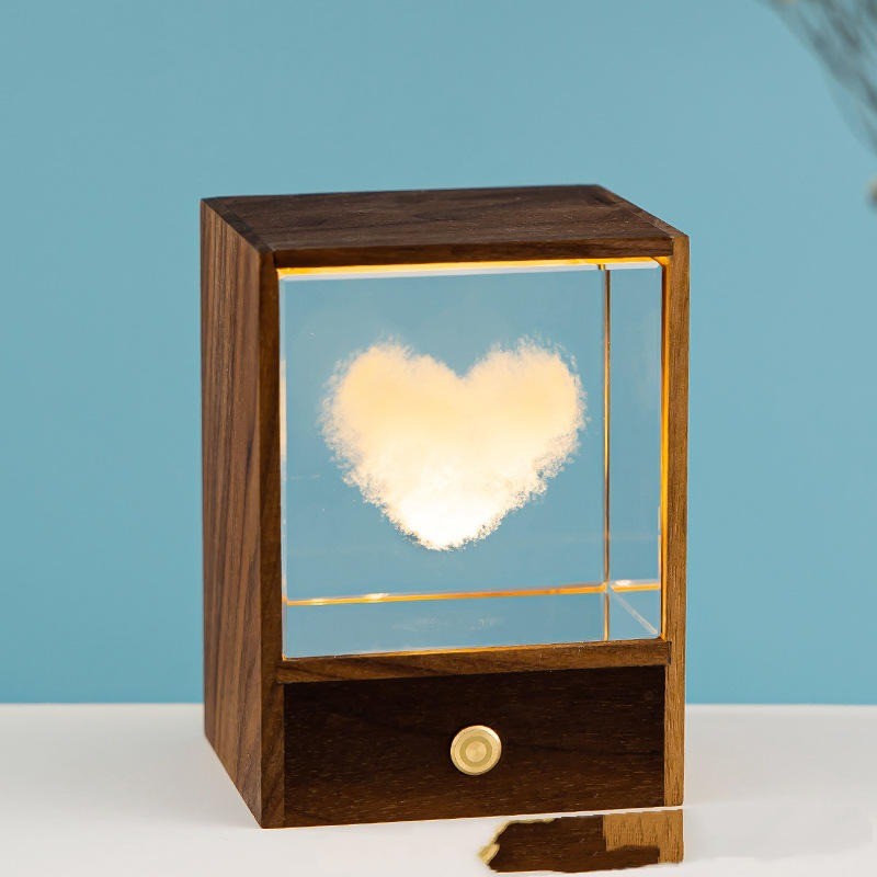 Cube de cristal gravé d’un cœur lumineux dans son écrin en bois
