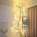 Guirlande branche de saule lumineuse fixée au mur d’une chambre