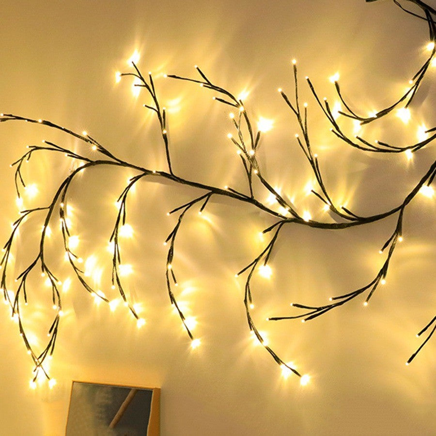 Guirlande de branches de saule illuminée sur un mur