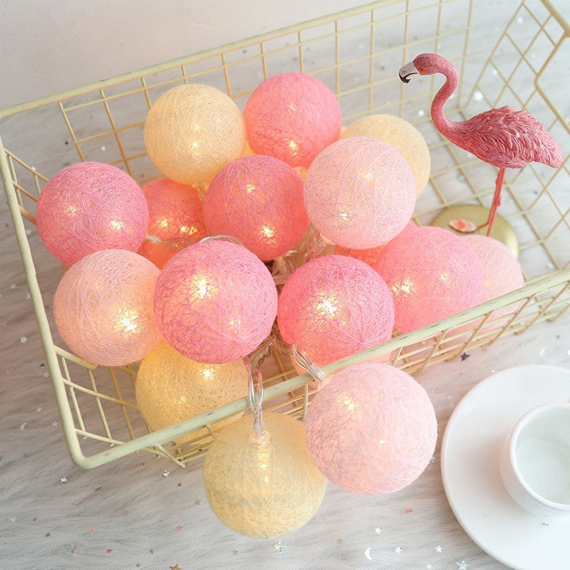 Guirlande de boules de coton roses allumées dans un panier