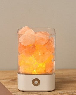 Lampe en cristaux de sel rose allumée sur une commode