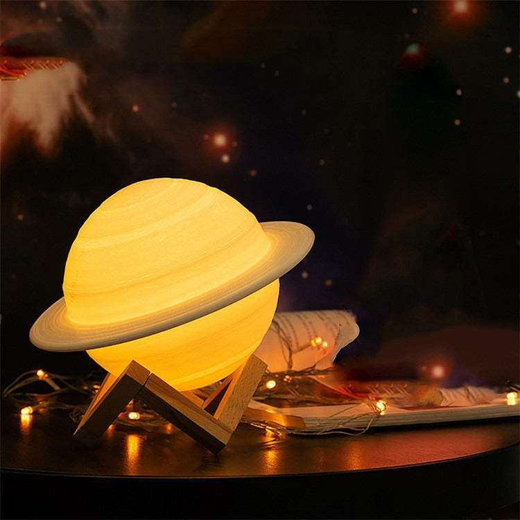 Lampe Saturne allumée en lumière chaude sur son support en bois