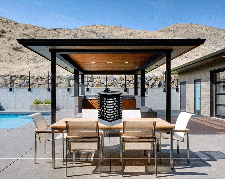 Lanterne solaire sur une table de jardin sous une pergola