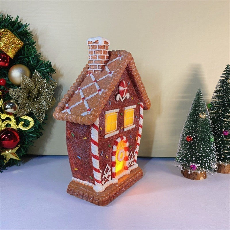 Maison en pain d’épices lumineuse vue de côté, près d’un sapin