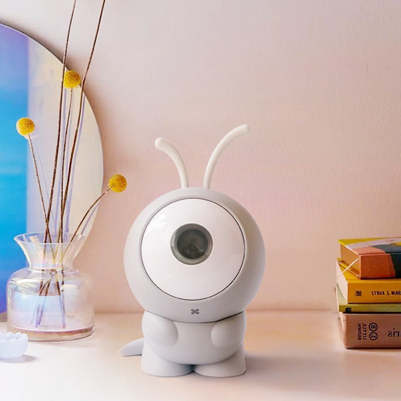 Mini projecteur galaxie gris posé sur une étagère