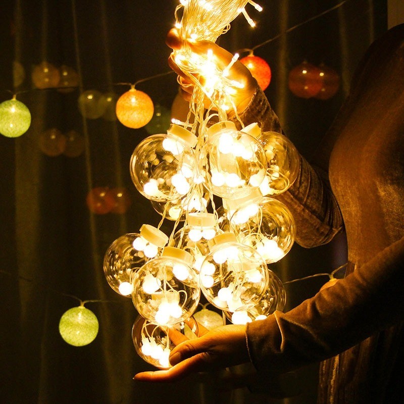 Grappe de bulles lumineuses blanc chaud tenue à la main