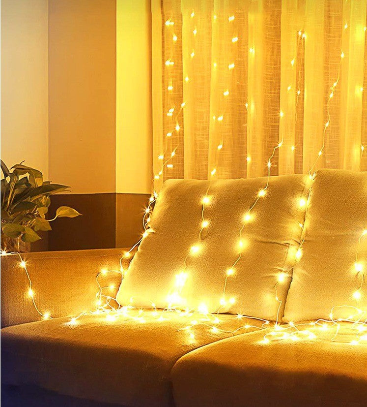 Rideau lumineux LED blanc chaud derrière un canapé