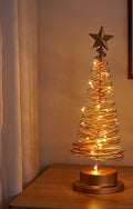 Sapin lumineux en fil de métal doré surmonté d’une étoile, lumière chaude