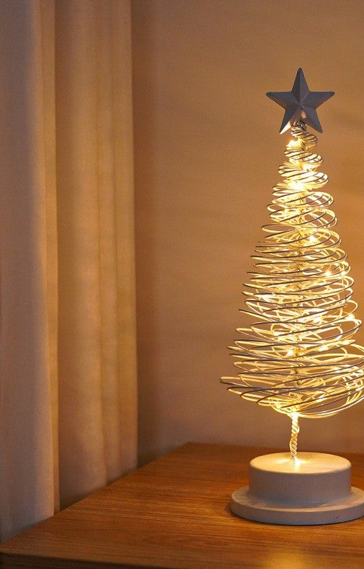 Sapin lumineux en fil de métal blanc, allumé dans un salon