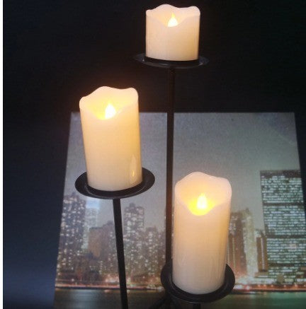Bougies LED en cire posées sur des bougeoirs en métal noir