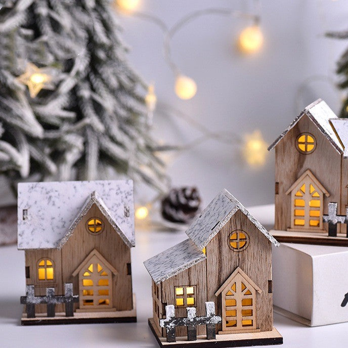 Trio de maisons en bois lumineuses posées près de pommes de pin