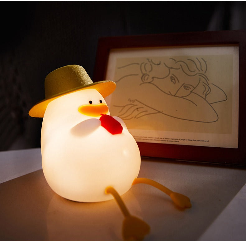 Veilleuse canard au chapeau devant un cadre
