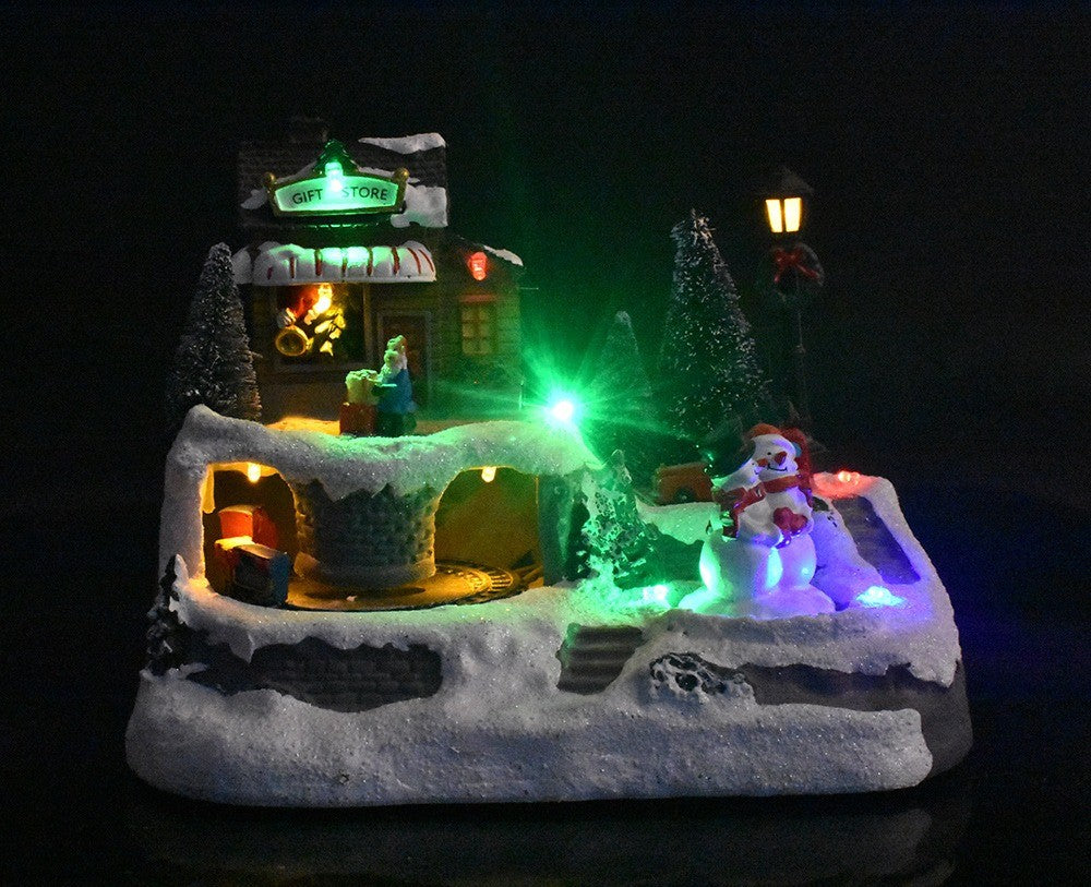 Village de Noël animé allumé dans la pénombre